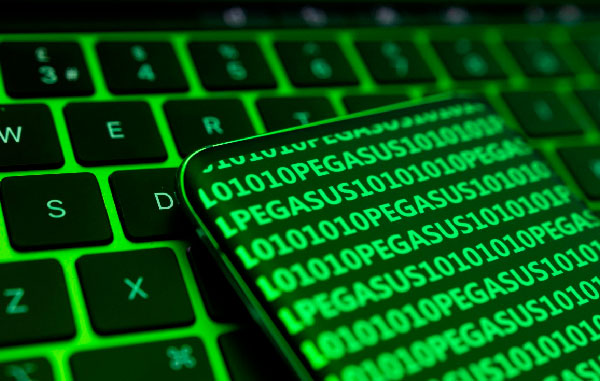 Punto de intercambio de tráfico (PIT) y gestión de datos nacionales Teclado de ordenador con reflejo verde de código binario y la palabra Pegasus, ilustrando el tráfico de datos del PIT.